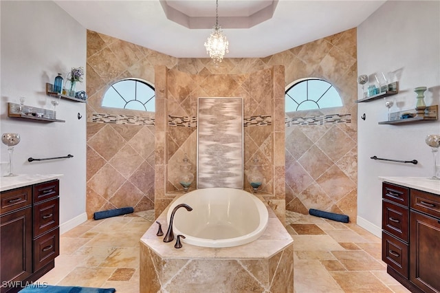 bathroom with a raised ceiling, vanity, and plenty of natural light