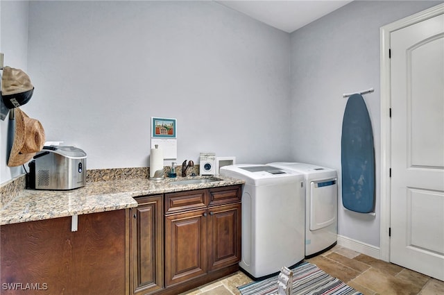 washroom featuring cabinets, sink, and washing machine and dryer