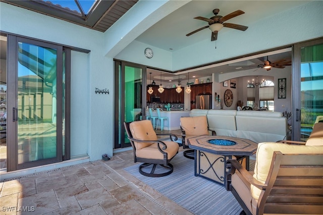 view of patio / terrace featuring ceiling fan and an outdoor living space with a fire pit