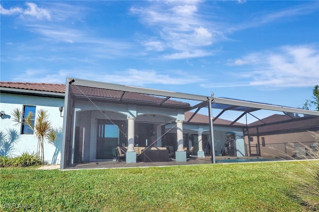 rear view of house with a lawn and glass enclosure