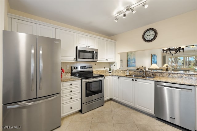 kitchen featuring sink, appliances with stainless steel finishes, white cabinetry, light stone countertops, and light tile patterned flooring