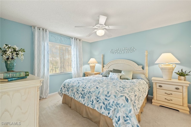 carpeted bedroom with ceiling fan and a textured ceiling