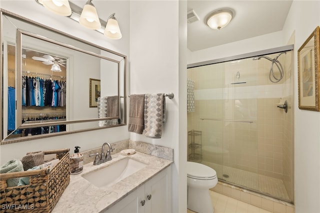 bathroom featuring vanity, tile patterned floors, toilet, and walk in shower