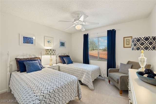 carpeted bedroom with ceiling fan and a textured ceiling