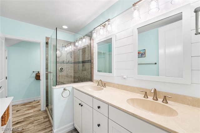 bathroom featuring an enclosed shower, vanity, and wood-type flooring