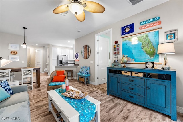 living room featuring ceiling fan, sink, and light hardwood / wood-style flooring