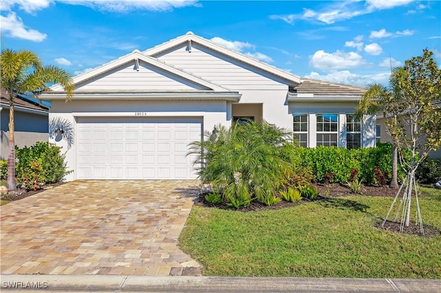 single story home featuring a garage and a front lawn