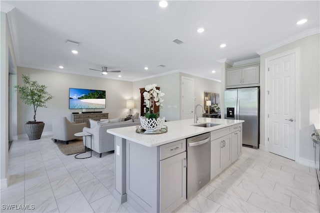 kitchen featuring stainless steel appliances, light countertops, a kitchen island with sink, and a sink