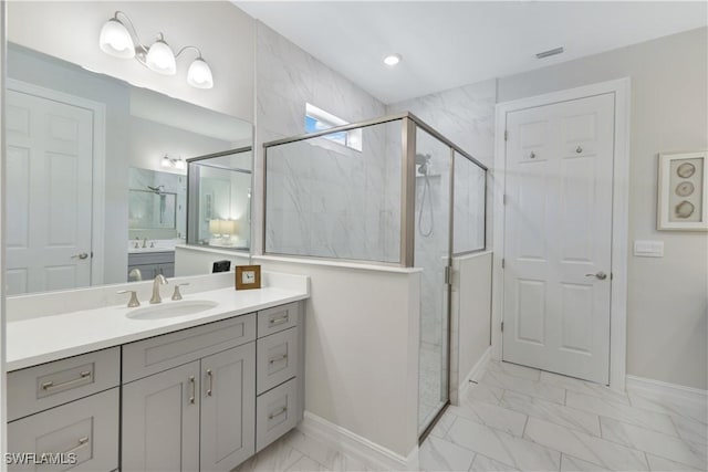 full bath featuring visible vents, vanity, baseboards, marble finish floor, and a marble finish shower