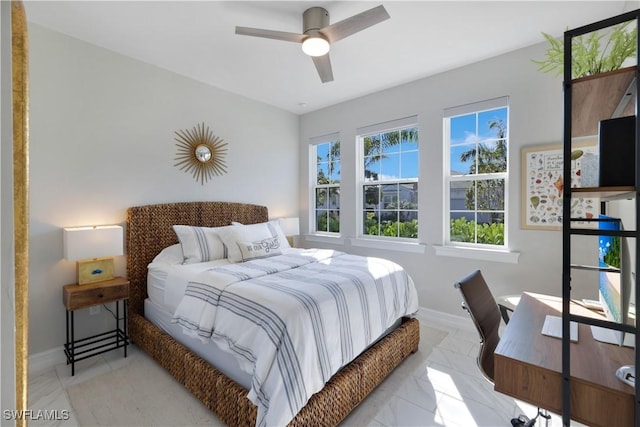 bedroom with ceiling fan, marble finish floor, and baseboards