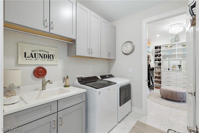 washroom with marble finish floor, separate washer and dryer, a sink, and cabinet space