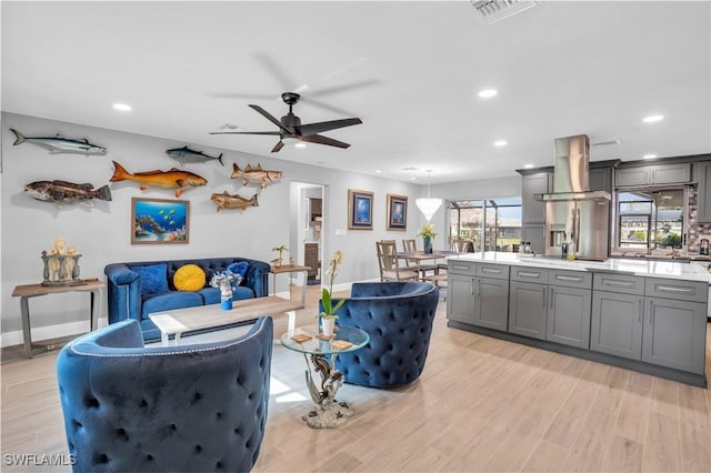 living room with ceiling fan and light hardwood / wood-style flooring