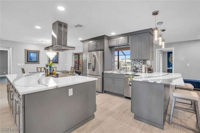 kitchen with stainless steel appliances, island exhaust hood, and gray cabinets