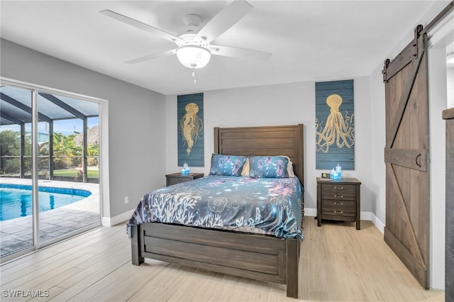 bedroom featuring access to exterior, light hardwood / wood-style flooring, a barn door, and ceiling fan