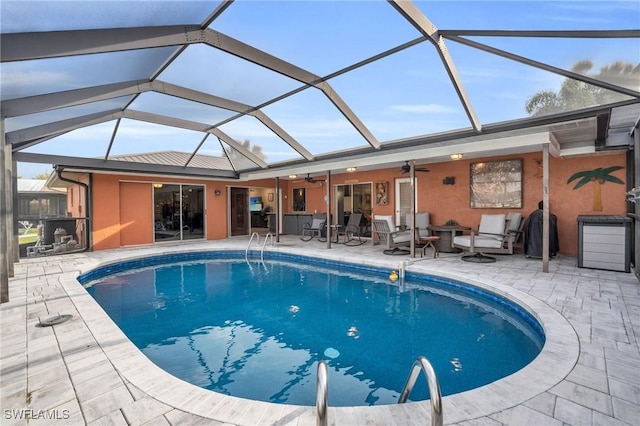 view of swimming pool with ceiling fan, a patio, and glass enclosure