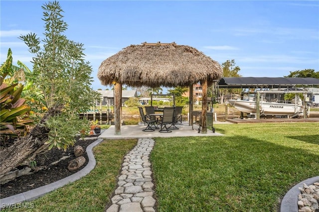 view of yard featuring a water view, a dock, and a gazebo