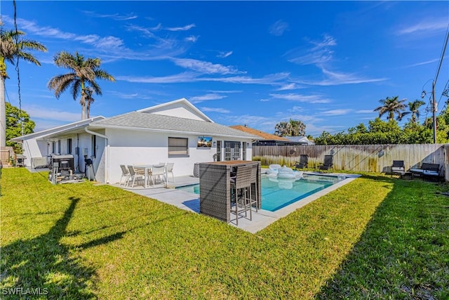 back of property with a fenced in pool, a yard, stucco siding, a patio area, and a fenced backyard