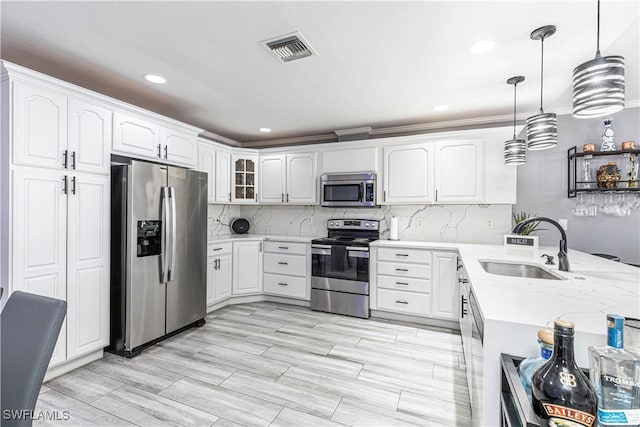 kitchen with stainless steel appliances, visible vents, a sink, and backsplash