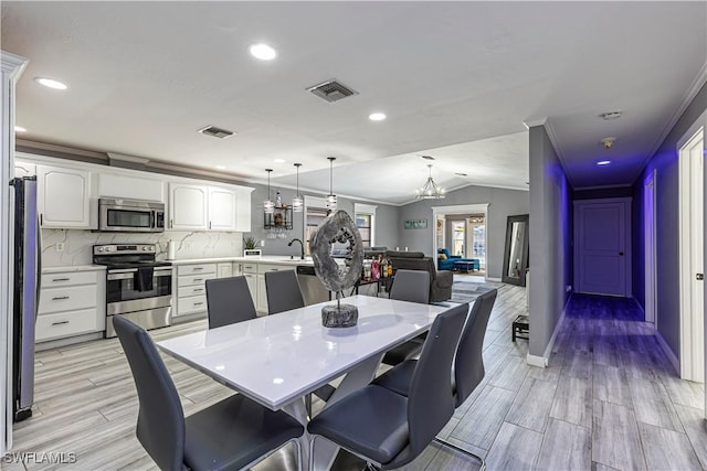 dining space with vaulted ceiling, wood tiled floor, visible vents, and an inviting chandelier