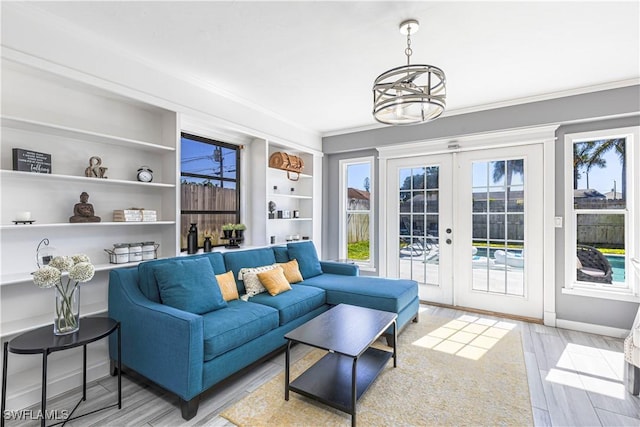 living room featuring french doors, a healthy amount of sunlight, baseboards, and light wood finished floors