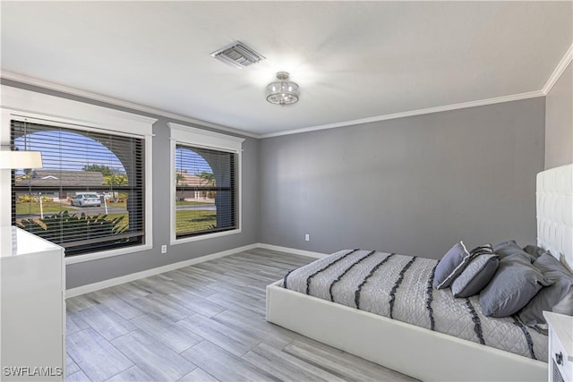 unfurnished bedroom with ornamental molding, visible vents, baseboards, and wood finished floors