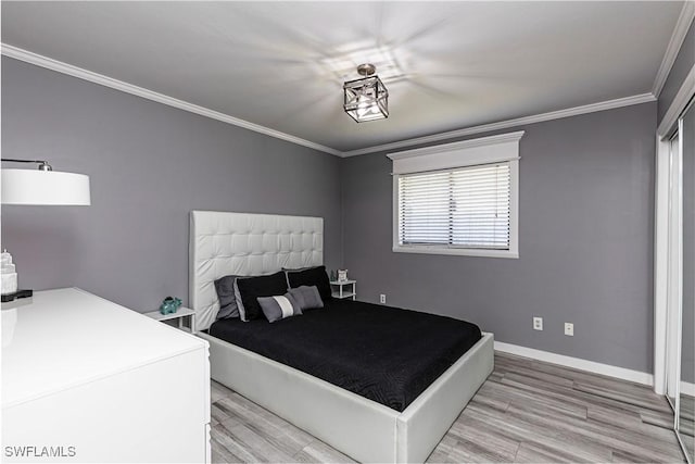 bedroom featuring baseboards, crown molding, and light wood finished floors