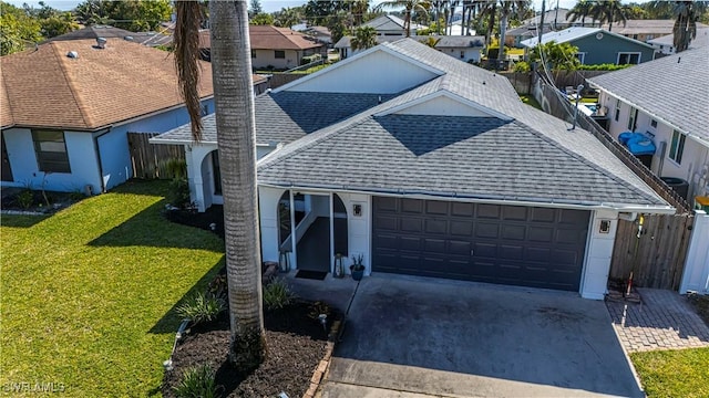 single story home featuring a garage, a shingled roof, driveway, a residential view, and a front yard