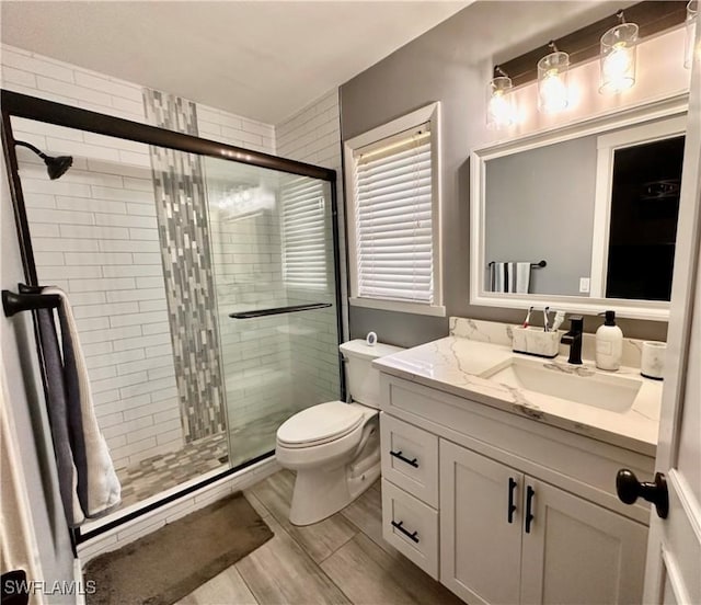 bathroom featuring a stall shower, vanity, and toilet