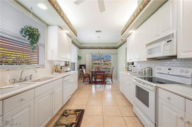 kitchen featuring sink, decorative light fixtures, light tile patterned floors, white appliances, and white cabinets