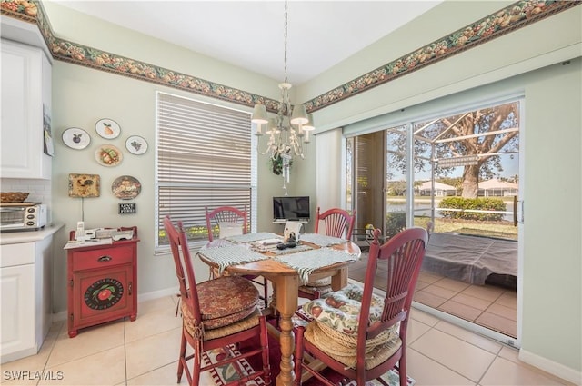 tiled dining room featuring an inviting chandelier