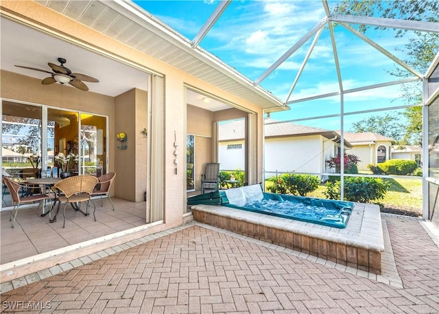 view of patio featuring ceiling fan and glass enclosure