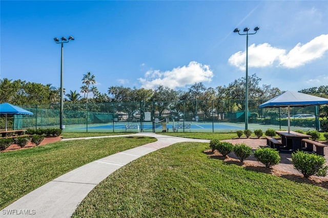 view of tennis court featuring a yard