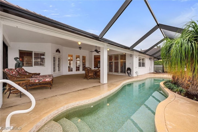 view of swimming pool featuring glass enclosure, ceiling fan, an outdoor living space, a patio area, and french doors