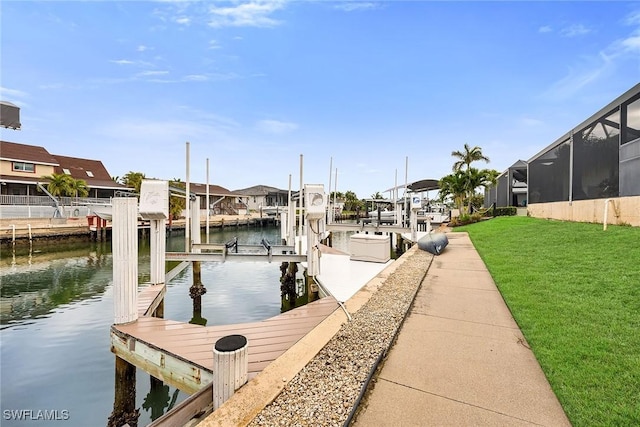 dock area featuring a water view, a yard, and a lanai