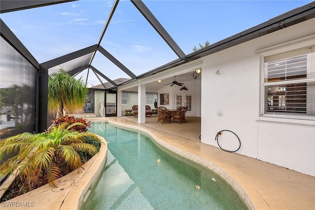 view of swimming pool featuring a lanai, a patio area, french doors, and ceiling fan