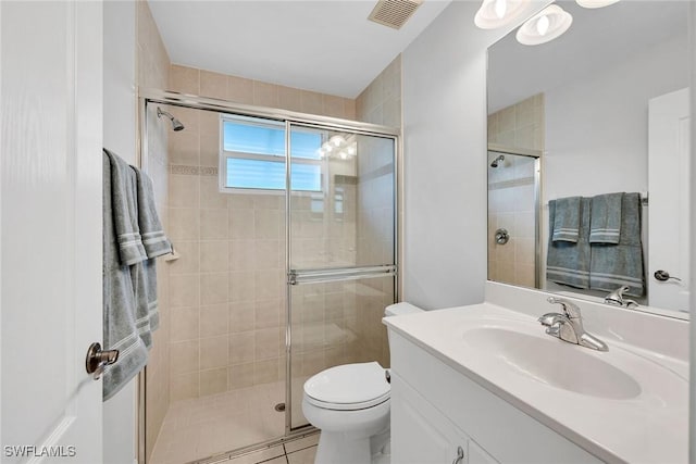 bathroom featuring vanity, an enclosed shower, and toilet