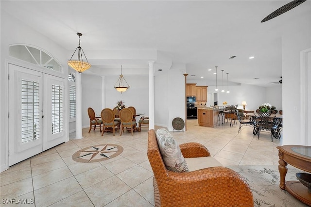 interior space featuring french doors, ornate columns, ceiling fan, and light tile patterned flooring