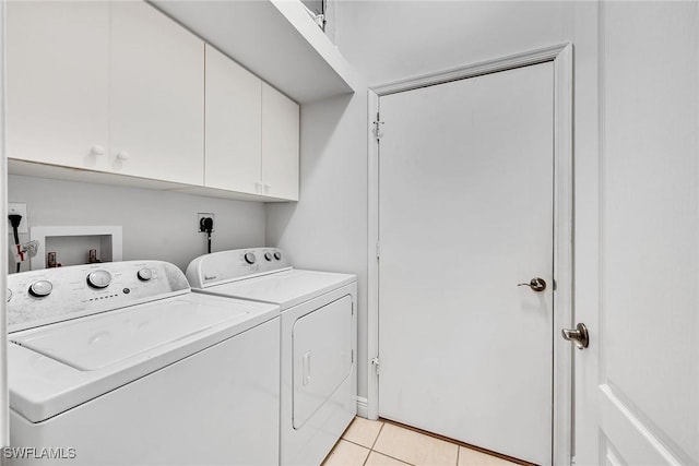 laundry area featuring independent washer and dryer, cabinets, and light tile patterned floors