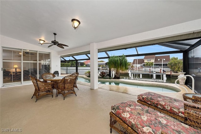 sunroom with a pool, vaulted ceiling, ceiling fan, and a water view