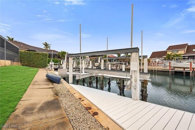 dock area with a water view and a lawn