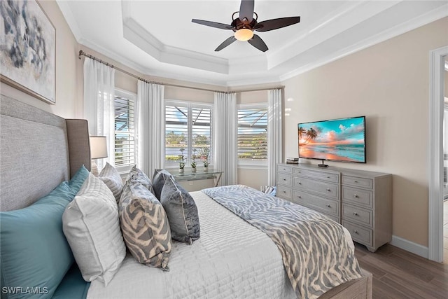 bedroom with hardwood / wood-style floors, ornamental molding, a raised ceiling, and ceiling fan