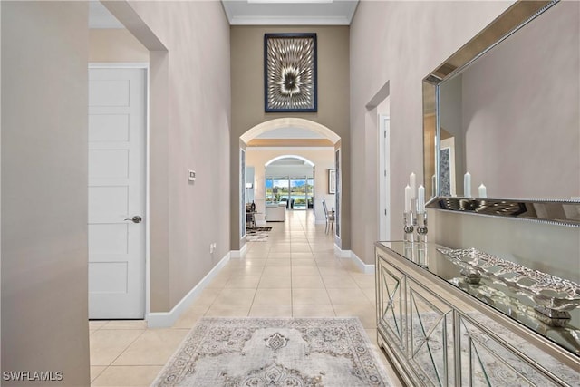 corridor with light tile patterned floors and crown molding