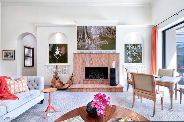 living room with crown molding and a premium fireplace