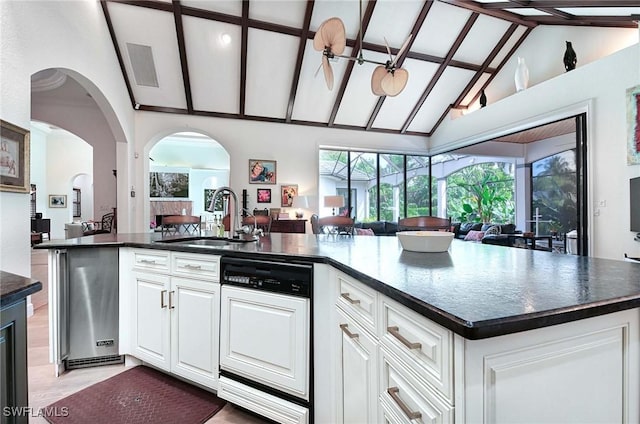 kitchen with white cabinetry, sink, dishwasher, and an island with sink