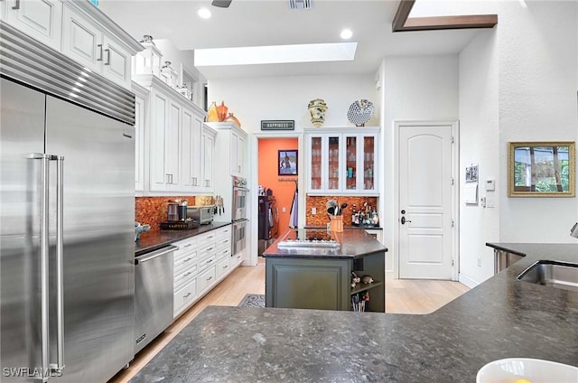 kitchen with stainless steel appliances, sink, a kitchen island, and white cabinets