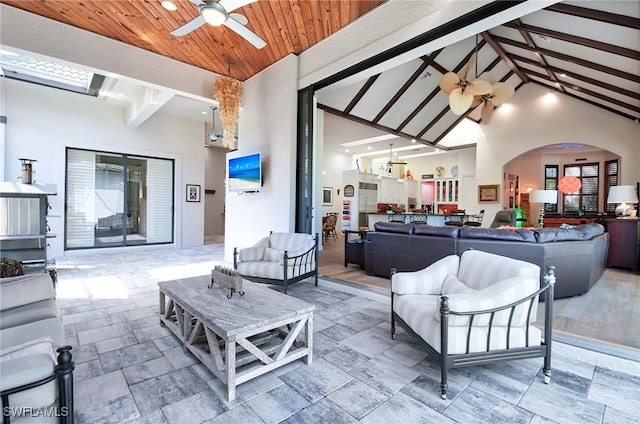 living room with beamed ceiling, high vaulted ceiling, wooden ceiling, and ceiling fan