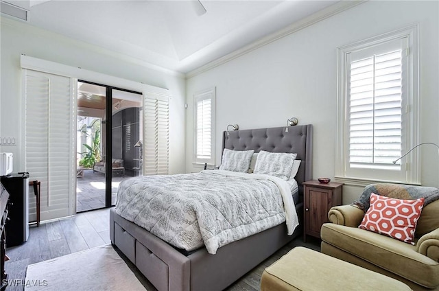 bedroom featuring multiple windows, access to exterior, and hardwood / wood-style floors