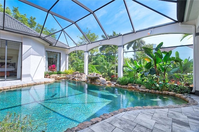 view of swimming pool featuring a lanai and a patio area