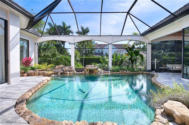 view of pool featuring glass enclosure and a patio area