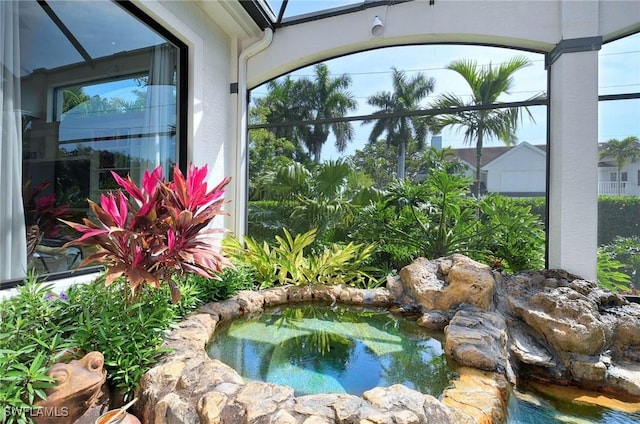 view of pool with a jacuzzi and a garden pond